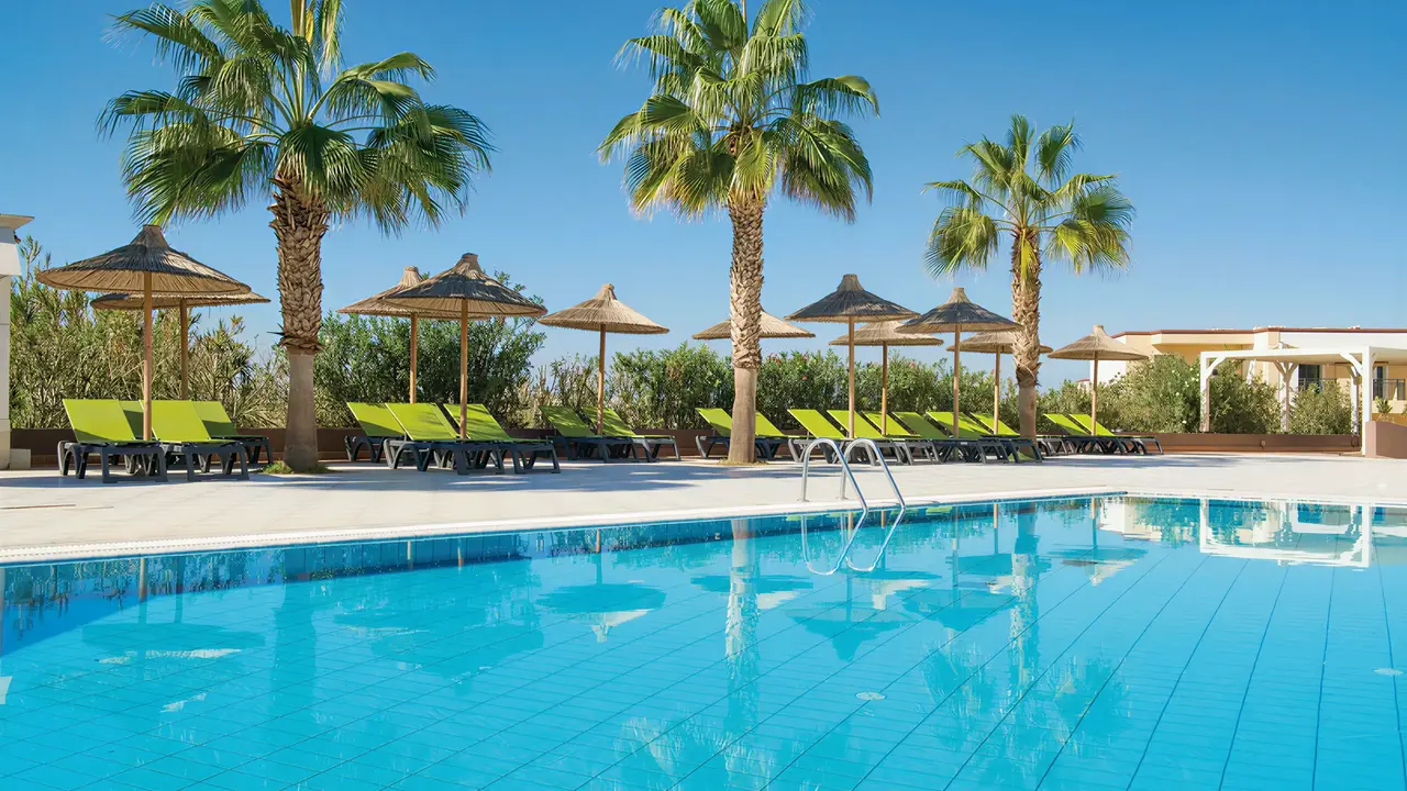Basen z leżakami i palmami w Gouves Water Park Holiday Resort