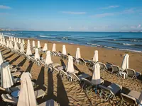 Leżaki i parasole na plaży w Gouves Water Park Holiday Resort