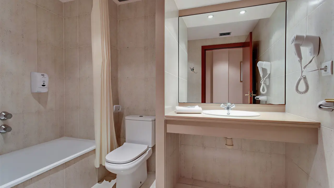 Łazienka w hotelu Gran Garbi z wanną i toaletą