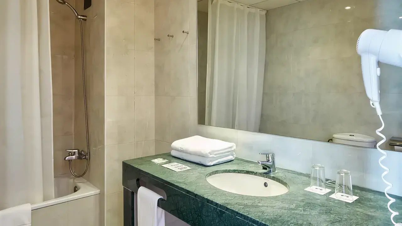 Łazienka w Gran Hotel Flamingo z zielonym blatem