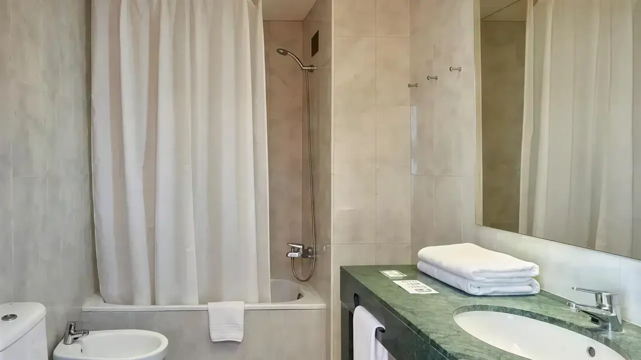Łazienka w hotelu Gran Hotel Flamingo z wanną i umywalką