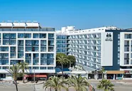 Elewacja budynku Gran Hotel Flamingo z palmami przed wejściem