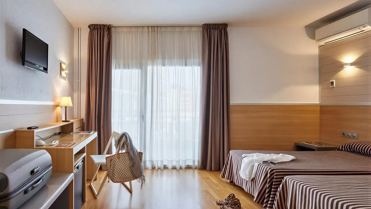 Pokój z łóżkami i biurkiem w Gran Hotel Flamingo