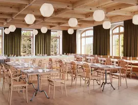 Jadalnia z drewnianymi stołami w Grand Hotel Belvedere