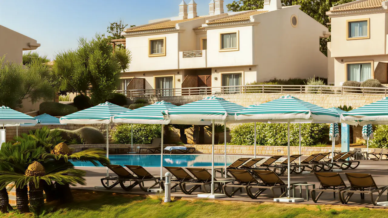 Basen z leżakami i parasolami w Grande Real Santa Eulalia