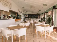 Jasna restauracja w Grande Real Santa Eulalia z białymi krzesłami