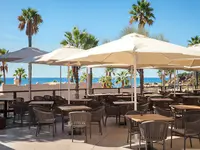 Stolik restauracyjny pod parasolem w Grande Real Santa Eulalia