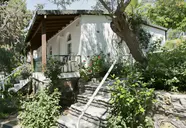 Biały budynek Green Port Bodrum otoczony zielenią i kwiatami