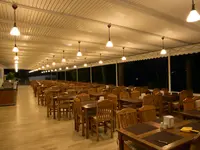 Restauracja w Green Port Bodrum z drewnianymi stołami i krzesłami