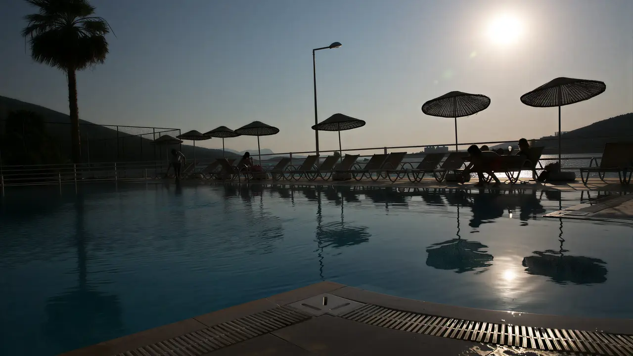 Basen z leżakami w Green Port Bodrum o zachodzie słońca