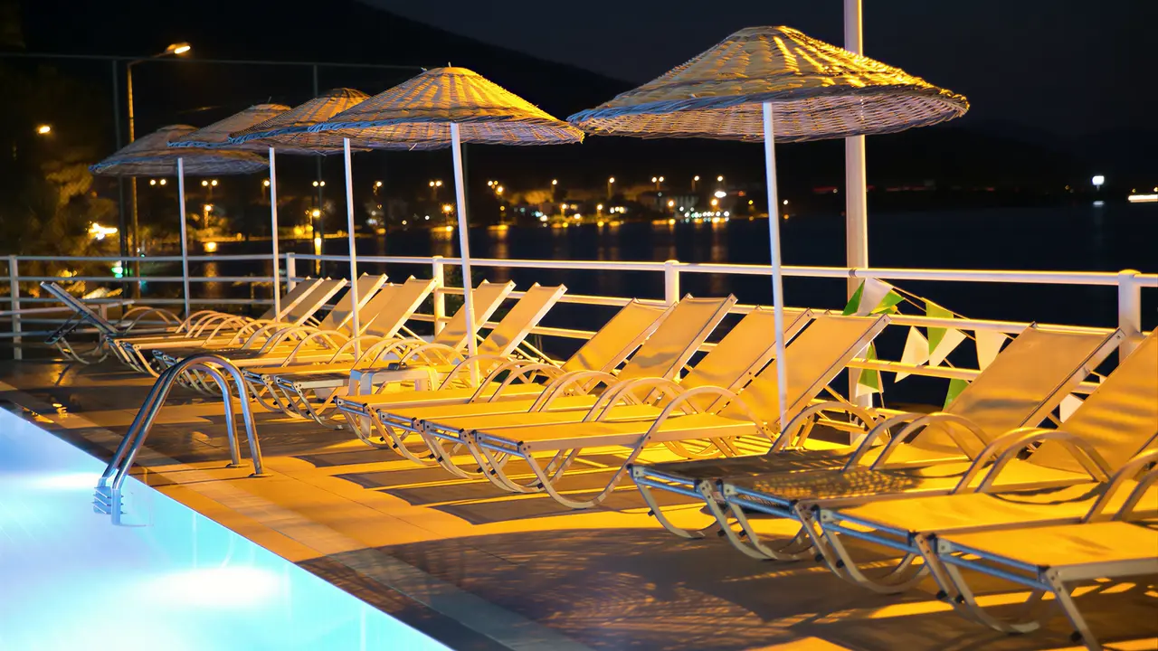 Leżaki przy basenie w Green Port Bodrum nocą