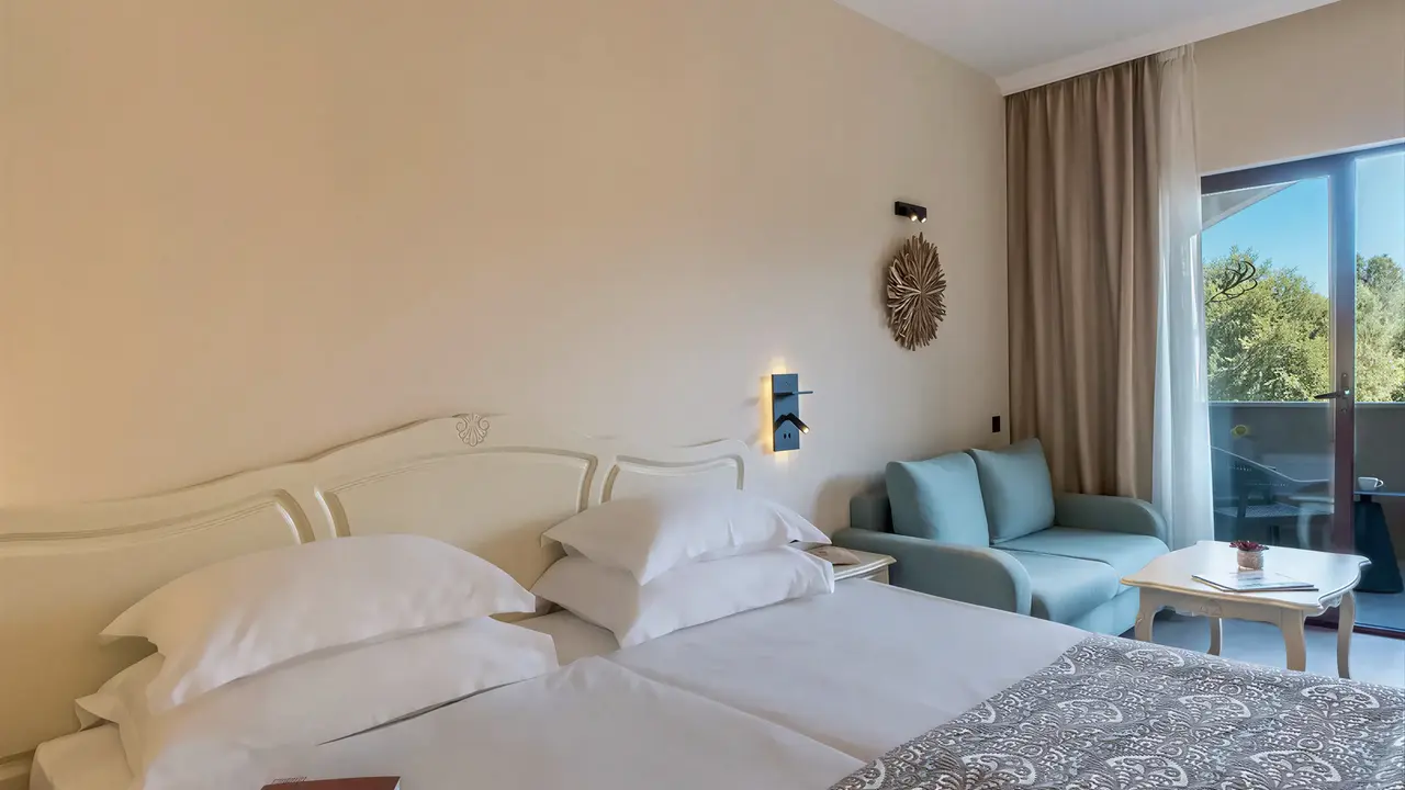 Sypialnia z łóżkiem i sofą w Grifid Aqua Club Bolero