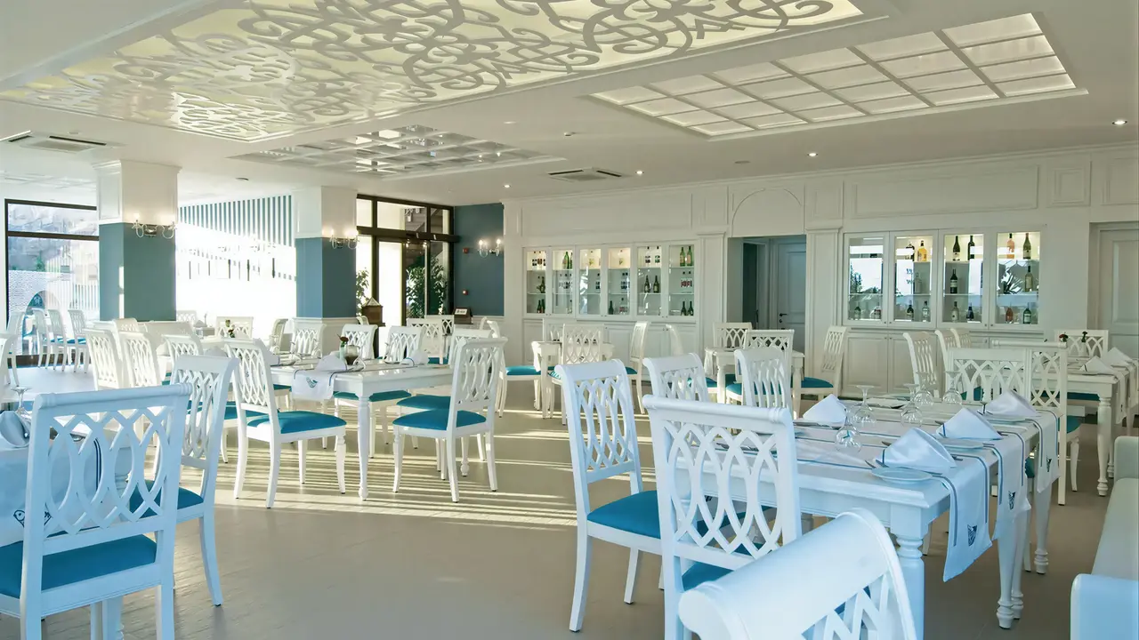 Jasna restauracja w Gypsophila Holiday Village z białymi meblami