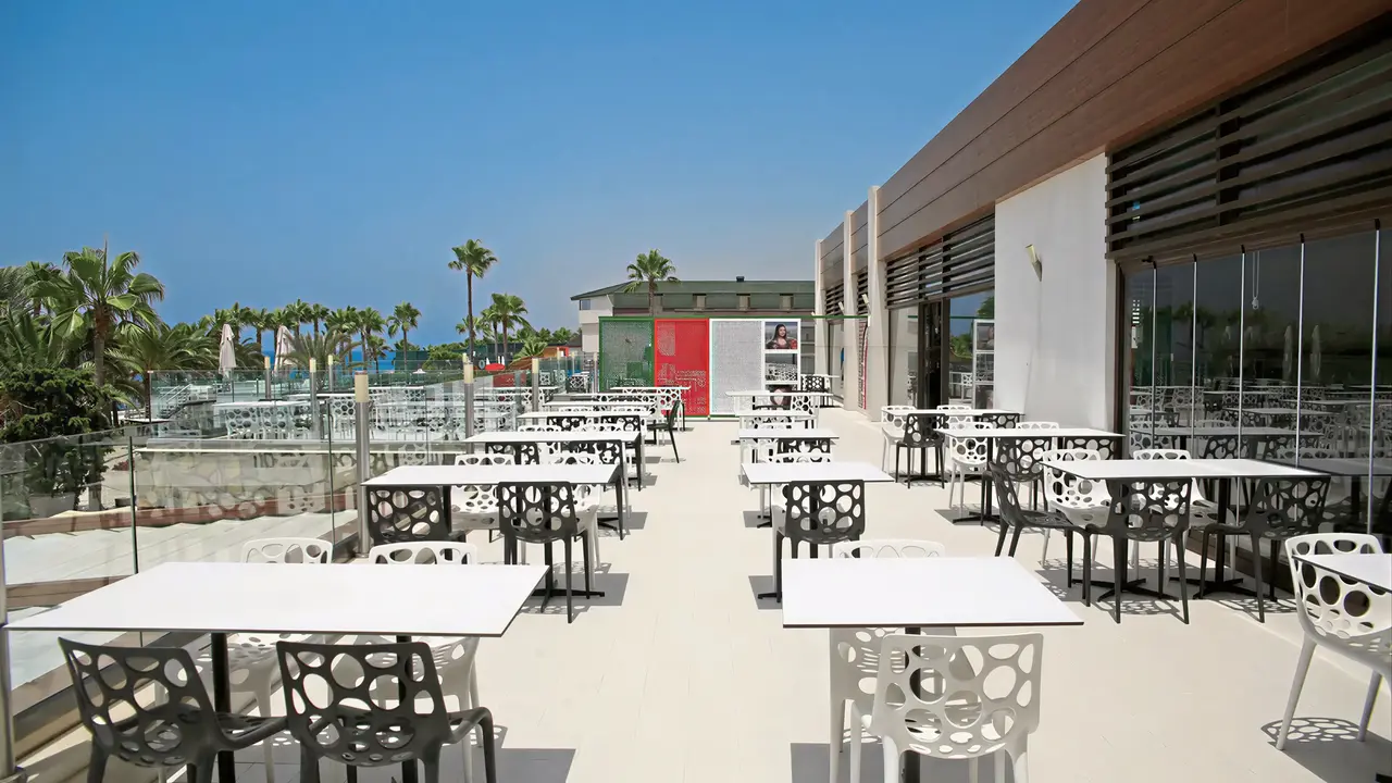 Taras restauracyjny w Gypsophila Holiday Village z białymi stolikami