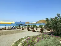 Plaża z leżakami i parasolami w Gypsophila Holiday Village