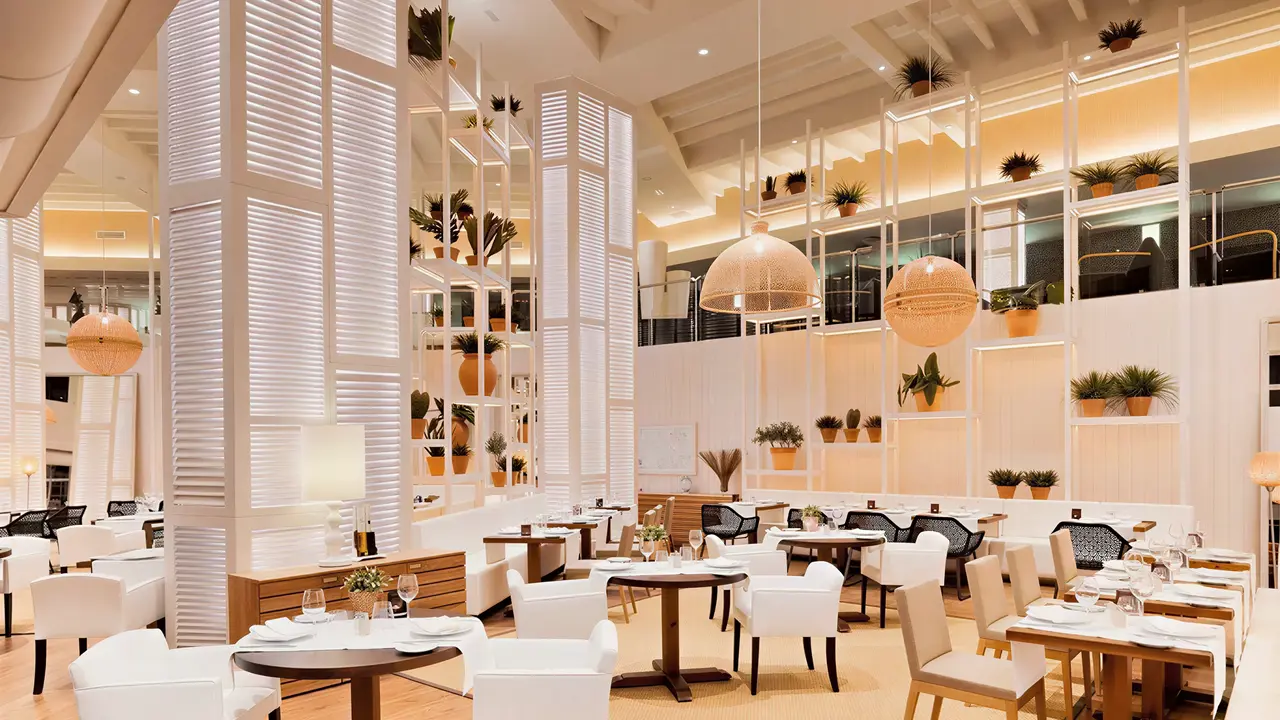 Elegancka restauracja w H10 Conquistador z białymi fotelami