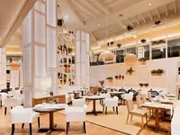 Elegancka restauracja w H10 Conquistador z białymi fotelami