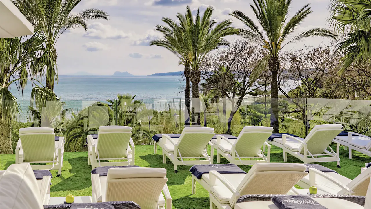 Leżaki na trawniku w H10 Estepona Palace z widokiem