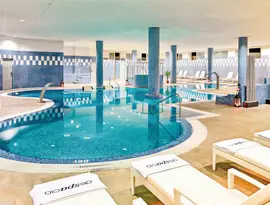 Kryty basen w H10 Estepona Palace z leżakami