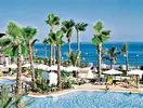 Basen z leżakami i palmami w H10 Estepona Palace
