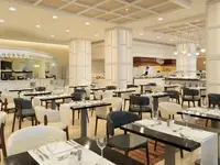 Elegancka restauracja w H10 Estepona Palace z ustawionymi stolikami