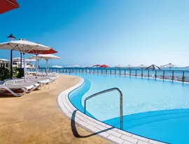 Basen z leżakami i parasolami w Hilton Malta