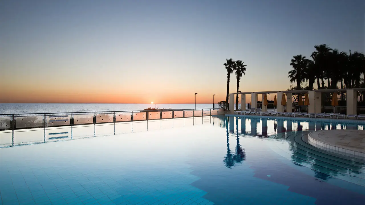 Basen infinity w Hilton Malta podczas zachodu słońca
