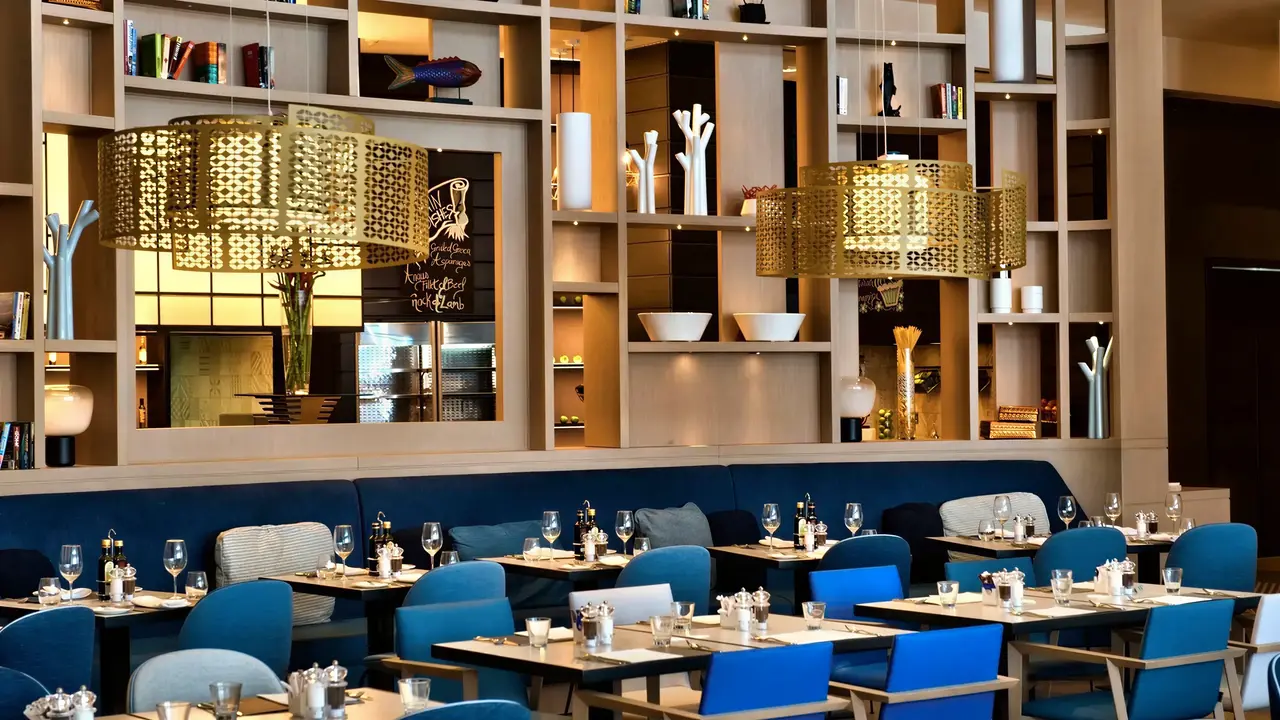 Elegancka restauracja w Hilton Malta z niebieskimi krzesłami