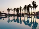 Basen z palmami o zachodzie słońca w Hilton Malta