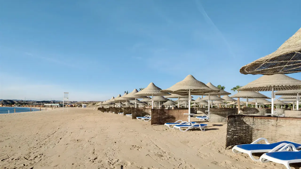 Plaża z leżakami i parasolami w Hilton Marsa Alam Nubian Resort