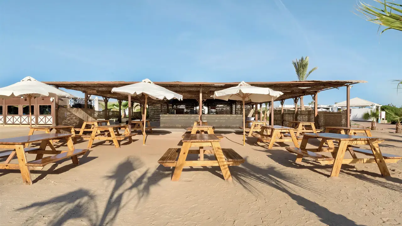 Drewniane stoły na plaży w Hilton Marsa Alam Nubian Resort