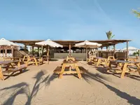 Drewniane stoły na plaży w Hilton Marsa Alam Nubian Resort