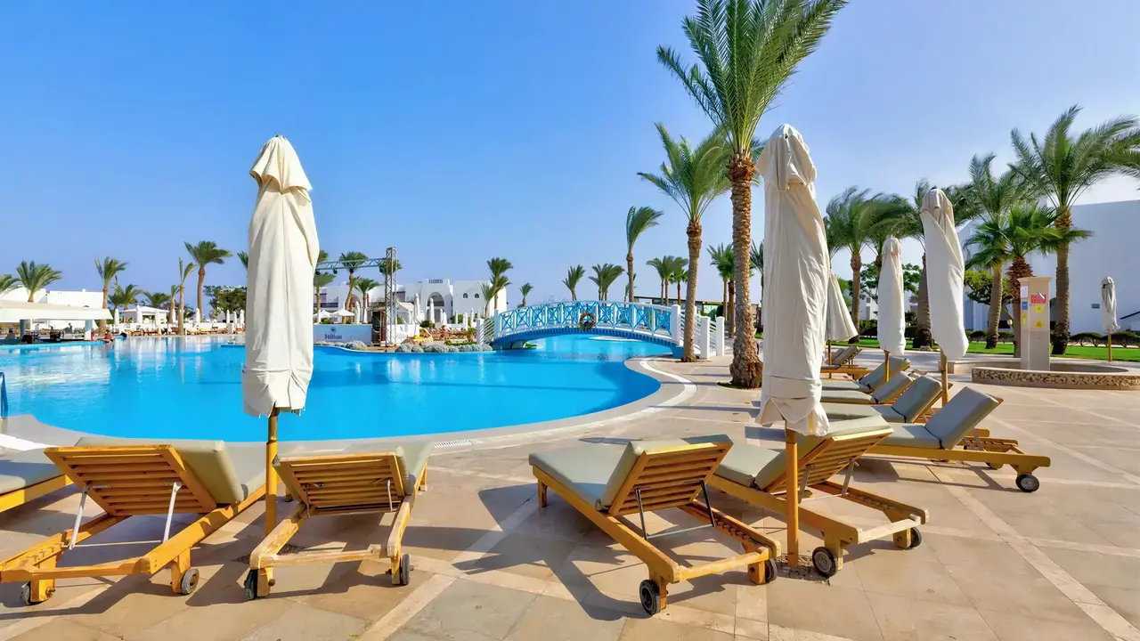 Basen z leżakami i parasolami w Hilton Marsa Alam Nubian Resort