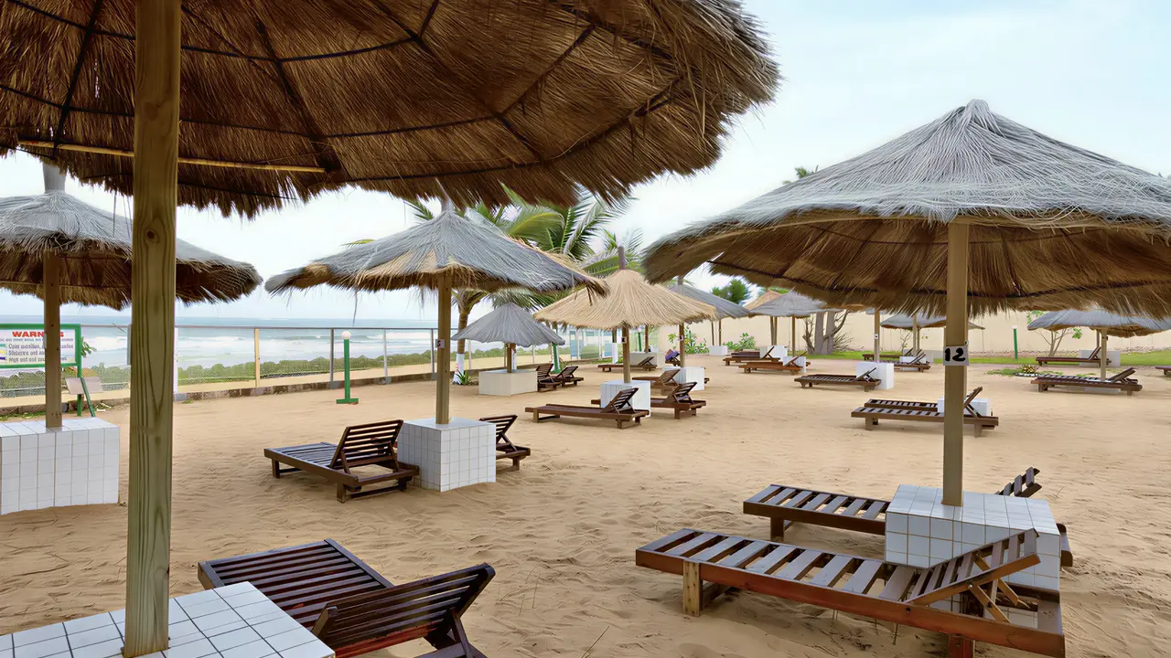 Leżaki i parasole na plaży w Holiday Beach Club