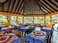Restauracja z nakrytymi stołami w Holiday Beach Club