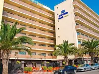 Elewacja budynku HTop Pineda Palace z palmami