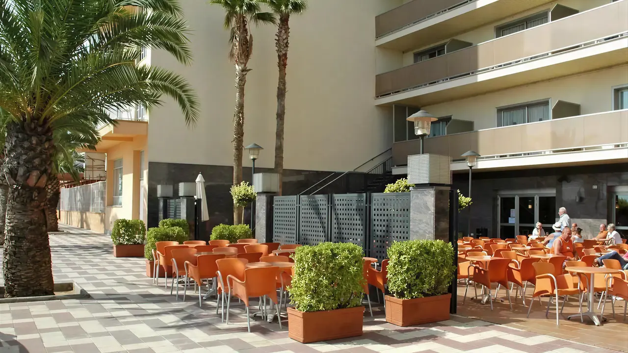 Taras restauracyjny w HTop Pineda Palace z pomarańczowymi krzesłami