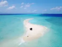 Piaszczysta wyspa i turkusowa woda w Hurawalhi Island Resort