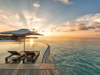 Basen typu infinity w Hurawalhi Island Resort o zachodzie słońca