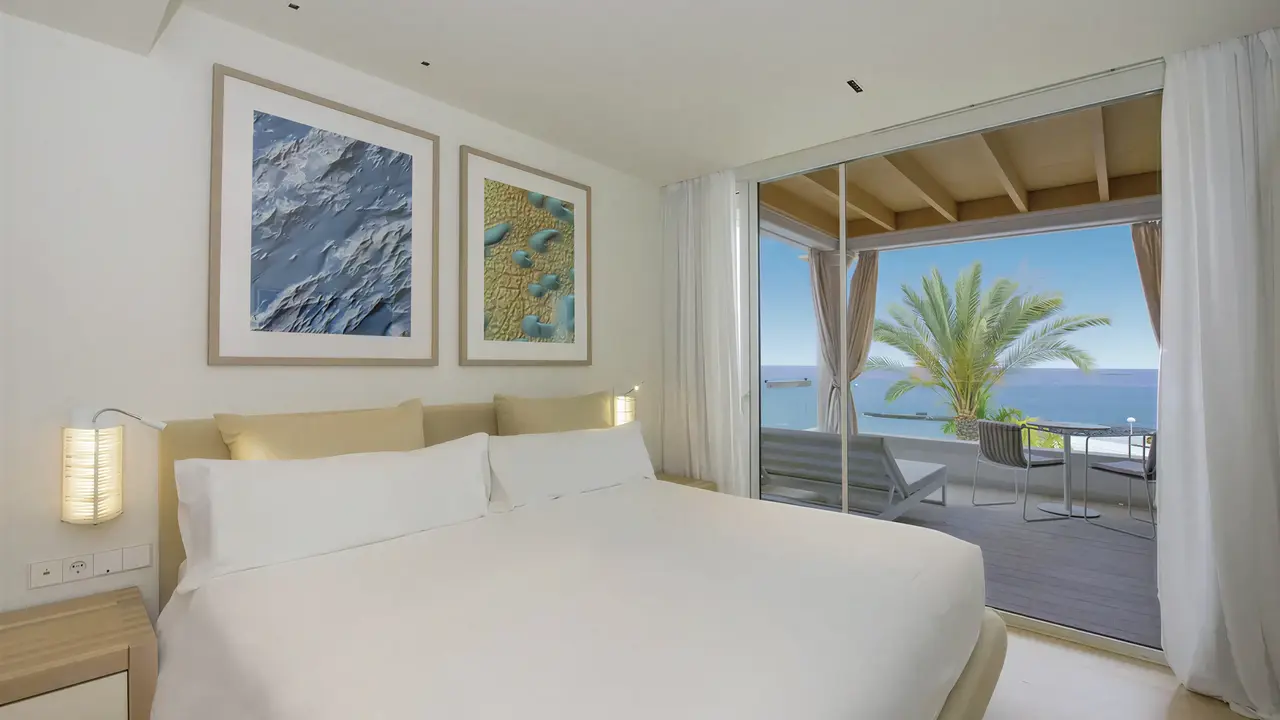 Jasna sypialnia w Iberostar Grand Salome z widokiem na taras