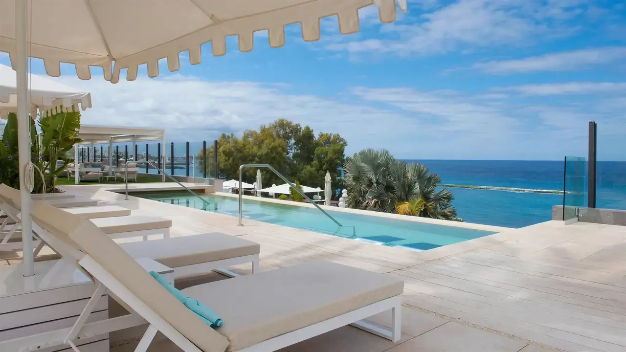 Basen z leżakami w Iberostar Grand Salome nad morzem