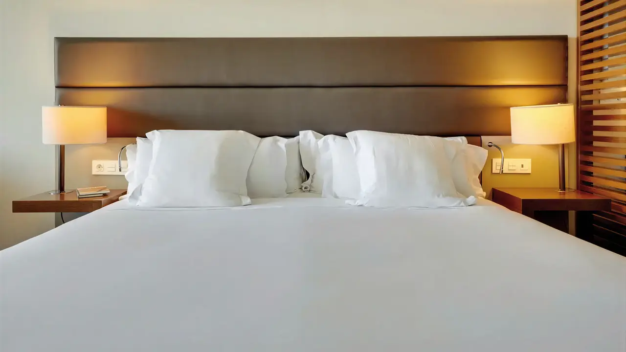 Łóżko z białą pościelą w Iberostar Lagos Algarve