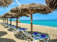 Leżaki pod słomianymi parasolami w Iberostar Origin Bella Vista
