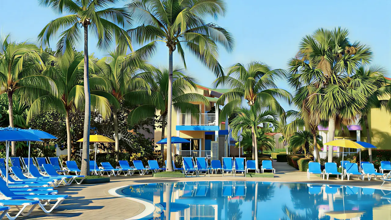 Basen z leżakami i palmami w Iberostar Origin Tainos