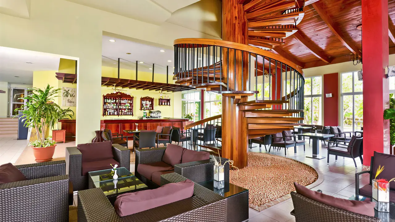 Wnętrze lobby z kręconymi schodami w Iberostar Origin Tainos
