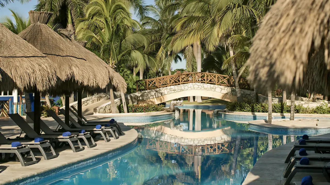 Basen z leżakami i mostkiem w Iberostar Paraiso Del Mar