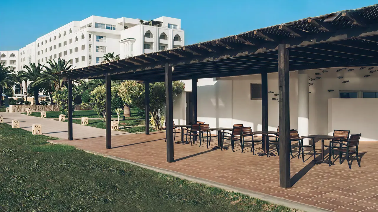 Taras z meblami i zieleń w Iberostar Selection Kantaoui Bay