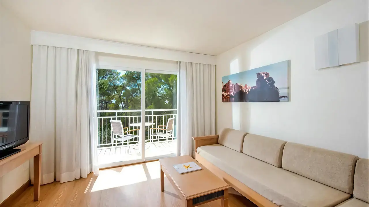 Pokój z salonem i balkonem w Iberostar Waves Club Cala Barca