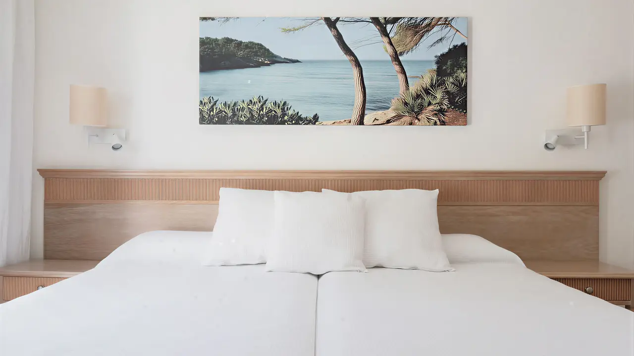 Sypialnia z białym łóżkiem w Iberostar Waves Club Cala Barca