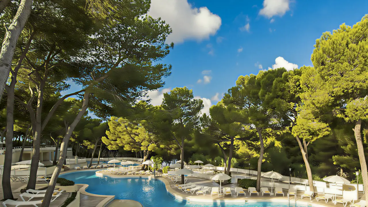 Basen z leżakami w otoczeniu drzew Iberostar Waves Club Cala Barca